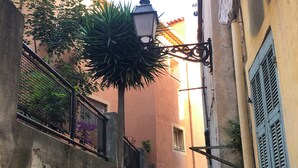 A narrow street with stone walls, a metal fence, and a street lamp. - RARE CHARMING APARTMENT IN OLD NICE, WITH A GARDEN VIEW, CLOSE TO THE SEA (Nice)
