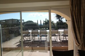 A balcony with a view of a terrace and outdoor seating area.