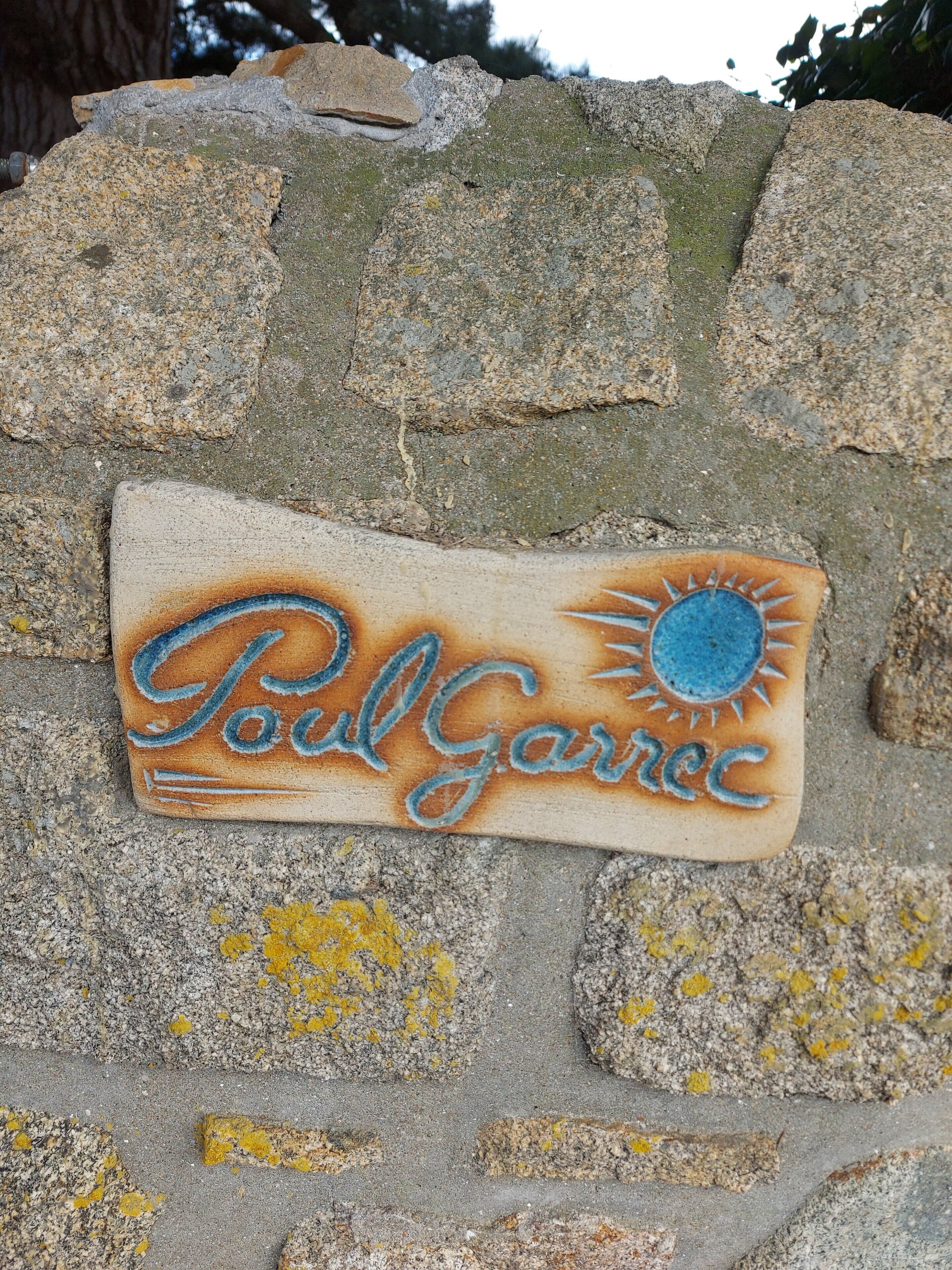 Eine Steintafel mit der Aufschrift 'Paul Garrec' und einem Sonnendesign.