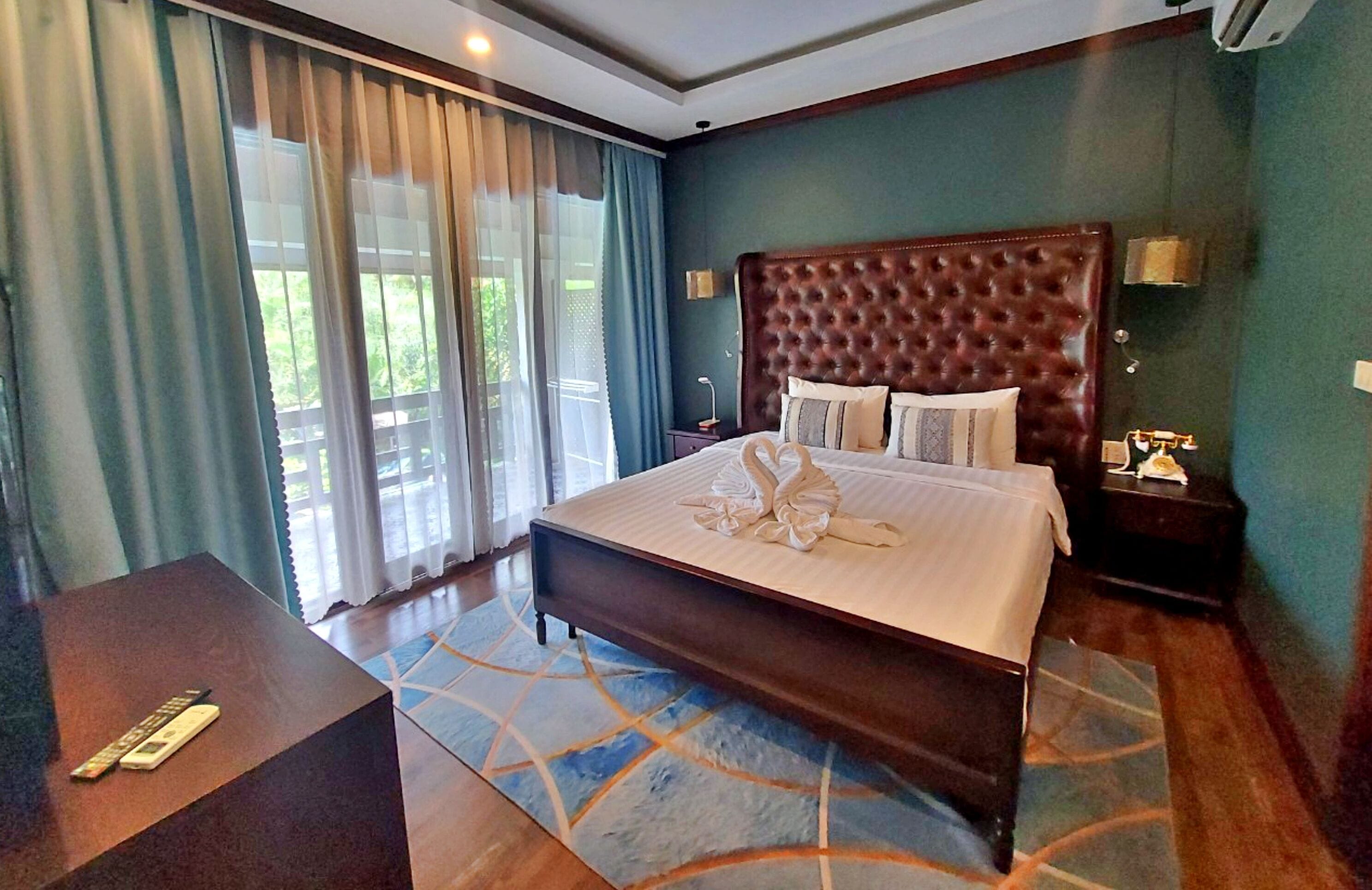 Een hotelkamer met een groot bed, een bureau en uitzicht op het omliggende landschap.