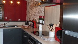 Una cocina moderna con una isla central, electrodomésticos de acero inoxidable e iluminación colgante.