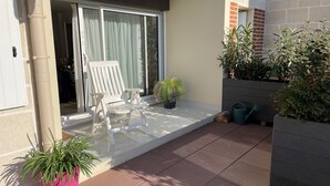 A balcony with a white chair, a potted plant, and a watering can. - Cabourg - Comfortable apartment 1 / 6pers WIFI in RDJ with terrace 100m beach (Cabourg)
