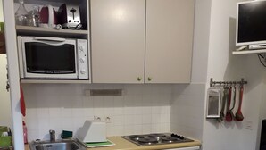 A compact kitchen with a microwave, stove, sink, and dishwasher. - COQUET STUDIO FEET OF THE TRACKS WELL EQUIPPED EXCEPTIONAL !!! ! (Risoul)