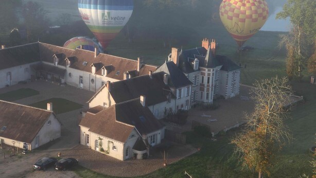 Un vaste domaine comprenant plusieurs bâtiments, dont une maison principale et plusieurs dépendances plus petites.