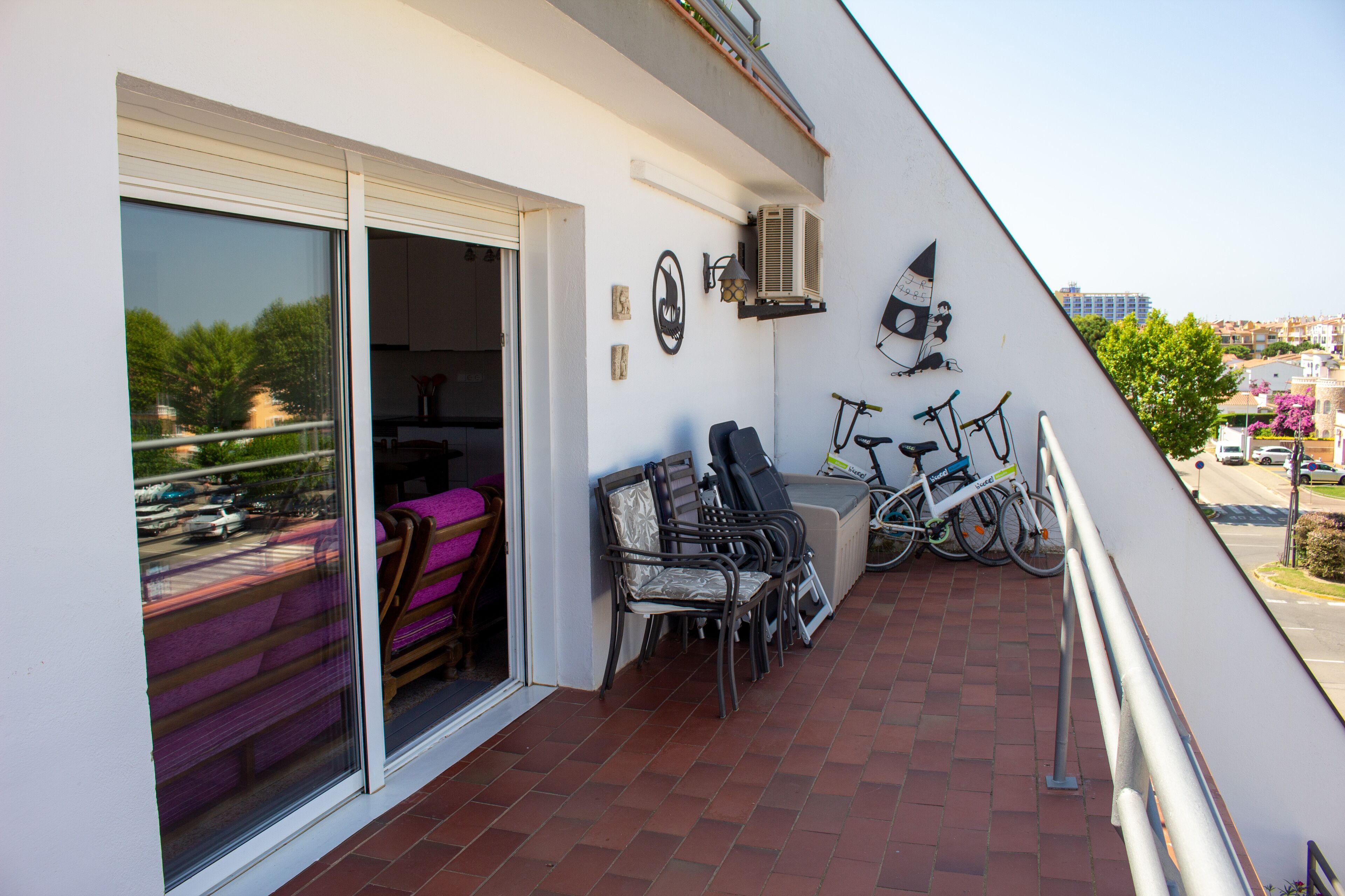 Un balcon avec une porte-fenêtre coulissante, un vélo et une chaise.