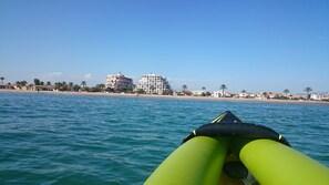 Blick auf einen Strand mit Gebäuden im Hintergrund.