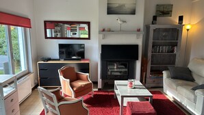 Un salon équipé d’un téléviseur, d’une cheminée et d’un espace détente.