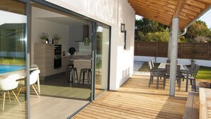 A modern house with a wooden deck, a glass-enclosed kitchen, and a pool. - Architect-designed villa between town center and beach - Heated pool (Capbreton)