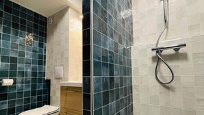 A bathroom with a shower, toilet, and sink.