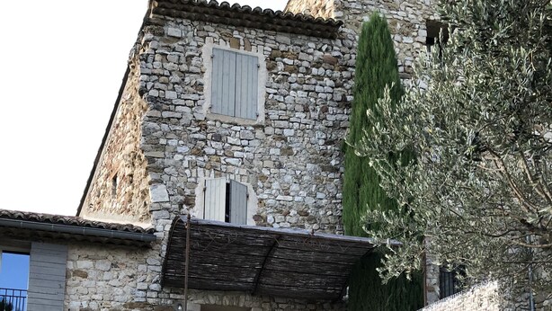 A stone building with a staircase leading to a wooden door. - Provencal house in a quiet and in the heart of the village of Gigondas (Gigondas)