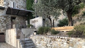 A stone building with a staircase leading to a balcony. - Provencal house in a quiet and in the heart of the village of Gigondas (Gigondas)