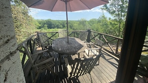 A wooden deck with a table and chairs, an umbrella, and a view of a forested area. - Beautiful Authentic Stone House In The Lot REDUCED RATE ! (Montcuq-En-Quercy-Blanc)