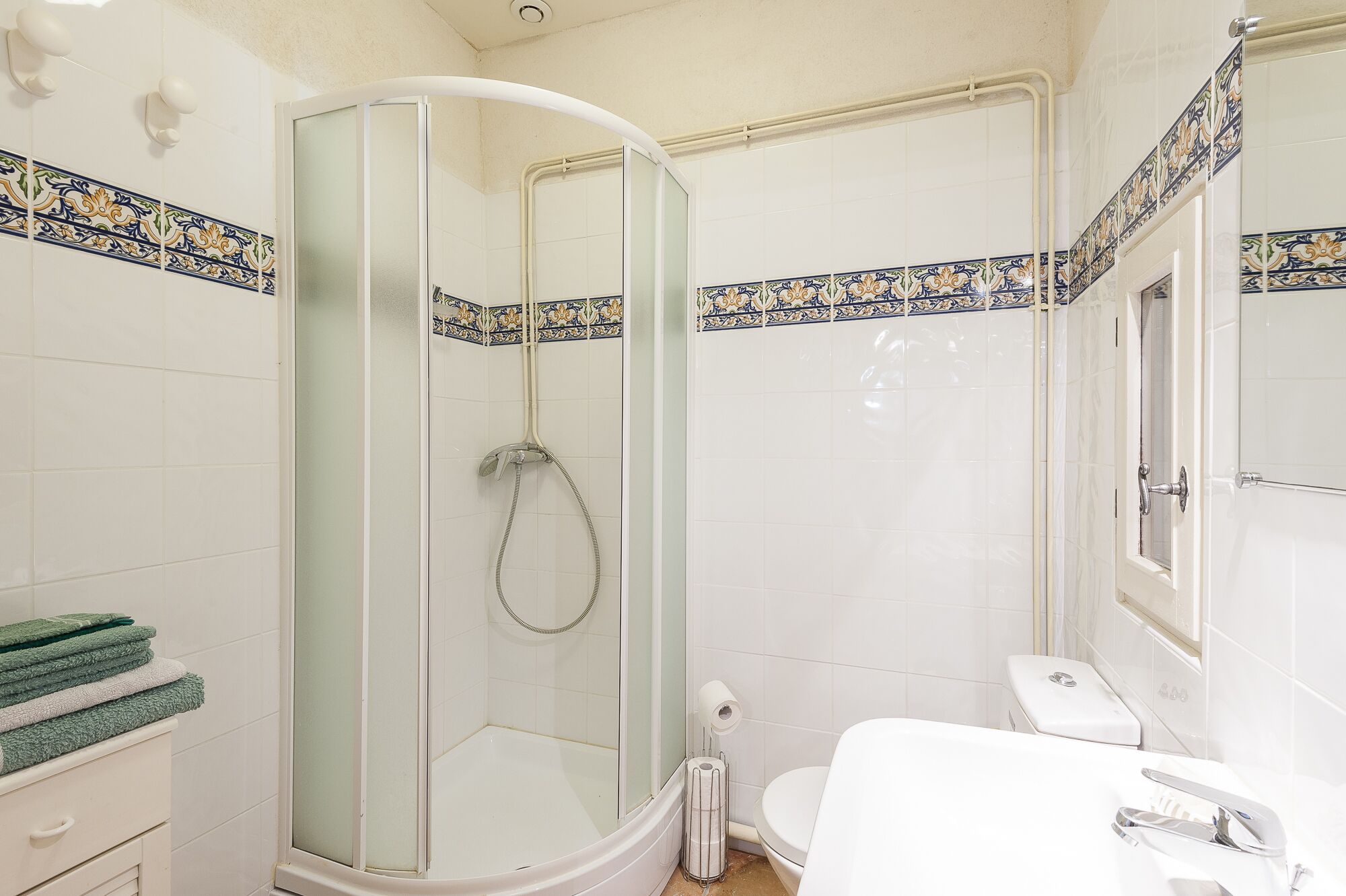 Une salle de bain avec une douche à parois de verre, des toilettes et un lavabo.