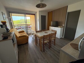 Ein kompakter Wohnbereich mit Essplatz, Küchenzeile und Balkon mit Blick.