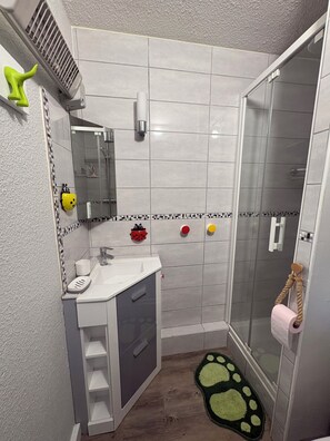 Ein Badezimmer mit Dusche, Waschbecken und Toilette.