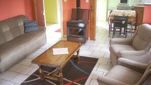 A living room with a sofa, armchairs, a coffee table, and a fireplace. - 2-star detached holiday home (Rochesson)