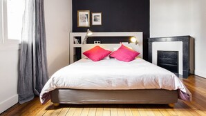 A bedroom with a bed, a fireplace, and a window with curtains. - The charm of a family home in Tours (Tours)