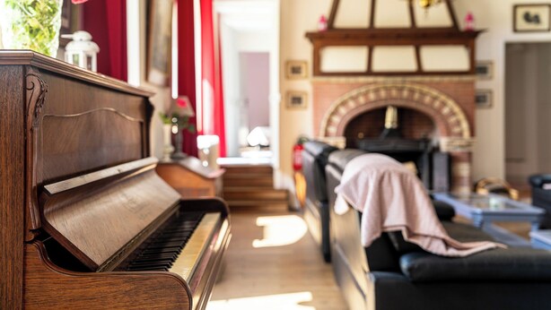 A grand piano in a cozy living room with a fireplace and a sofa. - Villa Mathilde, a 2-minute walk from the beach (Saint-Pierre-en-Port)