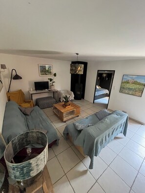 A living room with a sofa, a coffee table, a TV, and a door leading to another room.