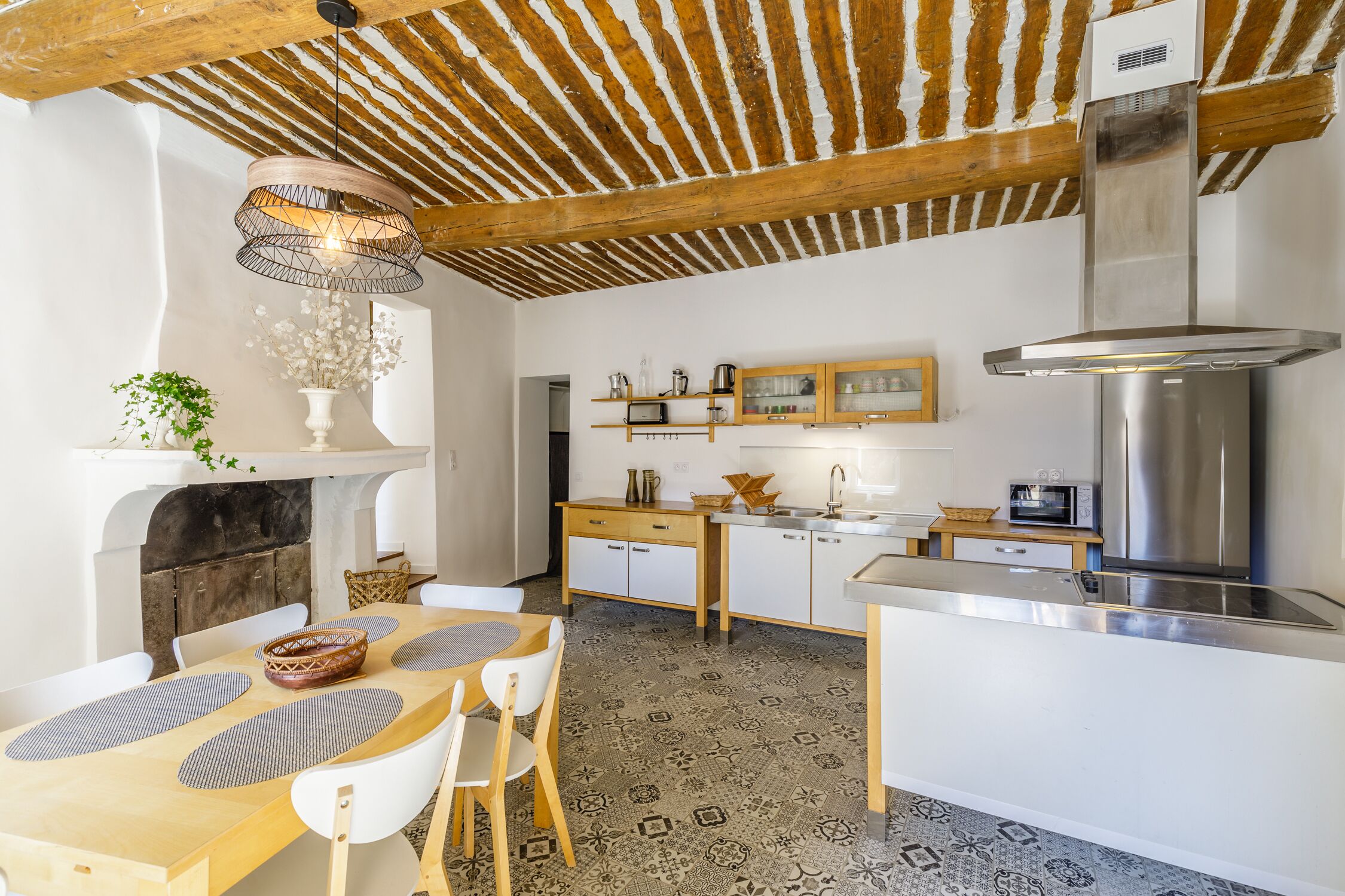 Une cuisine moderne avec un plafond en bois, un îlot central et une cuisinière intégrée.