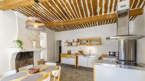 Una cocina moderna con techo de madera, una isla central y estufa empotrada.