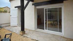 Un edificio con tetto in tegole, porta scorrevole in vetro e patio in pietra.