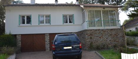 Een twee verdiepingen tellend huis met een auto op de oprit.