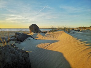A sandy beach with large rocks and sparse vegetation. - Bastide "villa cinnamon 'Agde - downtown (Agde)