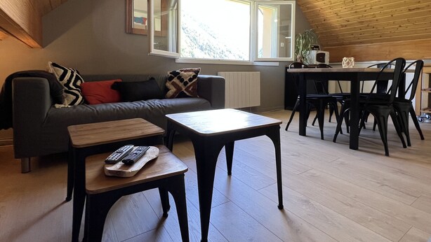 Un salon confortable avec un canapé, une table basse et un coin repas comprenant des chaises et une table.