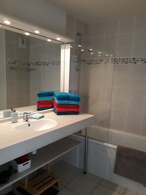 Bathtub, hair dryer, towels, toilet paper