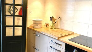 Eine moderne Küche mit einer Holz Arbeitsplatte, einem eingebauten Ofen und einer Glastür mit einem dekorativen Gegenstand.