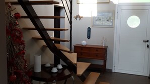A staircase with a wooden finish and black railings, leading to a landing with a small wooden table and a white door. - Bassin d'Arcachon - Beautiful house near the port of Cassy (Lanton)