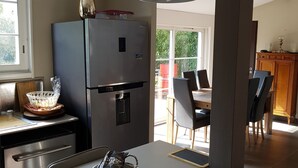 A modern kitchen with a large island, stainless steel appliances, and pendant lighting. - Bassin d'Arcachon - Beautiful house near the port of Cassy (Lanton)