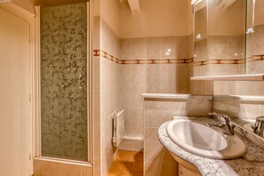 Combined shower/bathtub, hair dryer, soap, toilet paper