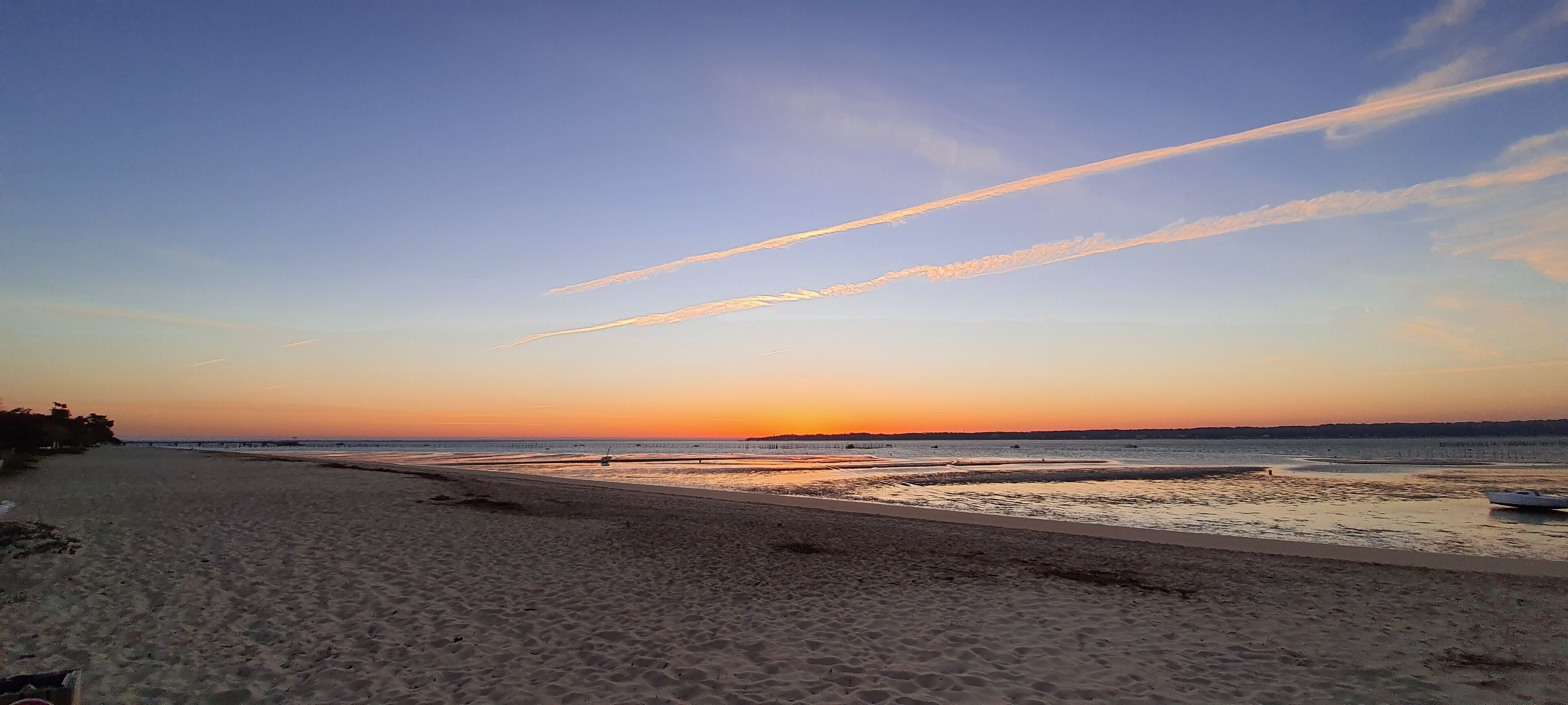 A beach with a clear sky and a sunset.