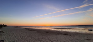 A beach with a clear sky and a sunset.