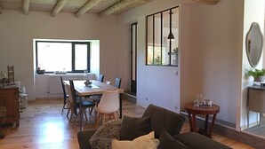 Un coin repas comprenant une table et des chaises, un meuble en bois et un canapé.