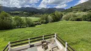 Un espacio al aire libre con un muelle de madera y vistas a colinas y montañas.