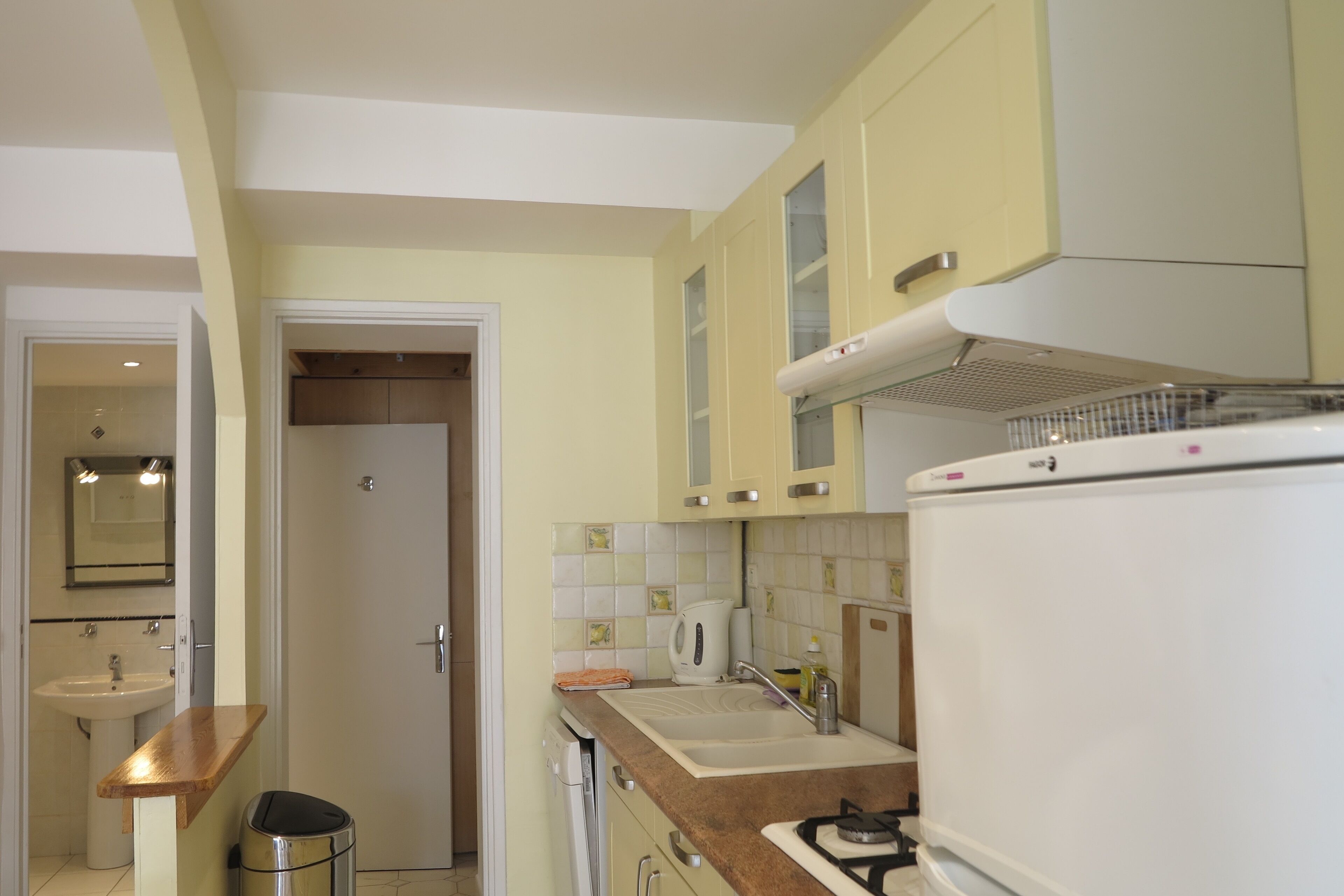 A compact kitchen with a sink, stove, and cabinets.