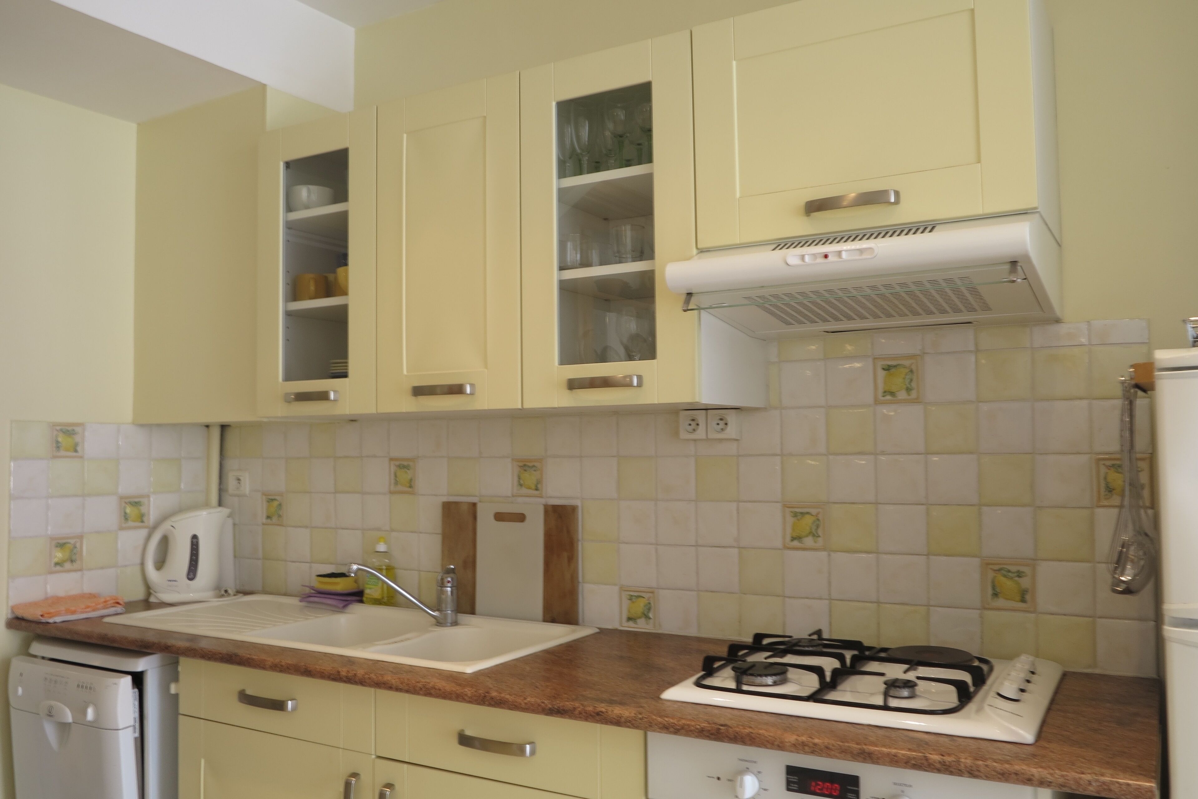 Una cocina con estufa a gas, pileta y alacenas.