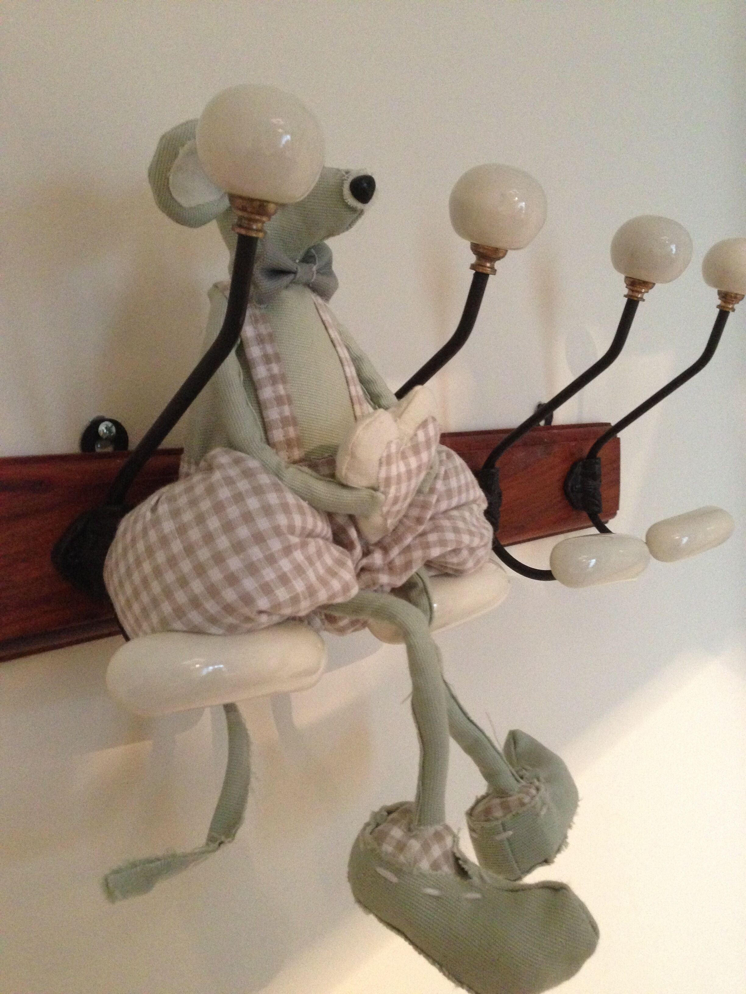 A decorative sculpture of a figure with a checkered bow and a pair of shoes, mounted on a wooden structure with multiple spherical lights.