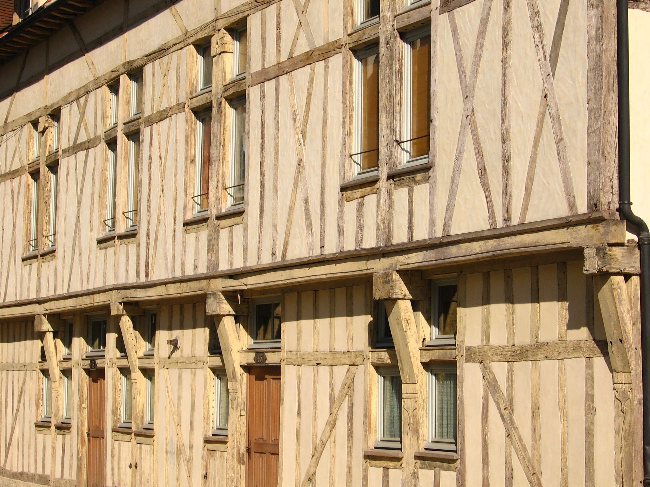 A half-timbered building with multiple windows and a wooden door.
