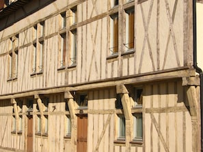 A half-timbered building with multiple windows and a wooden door.