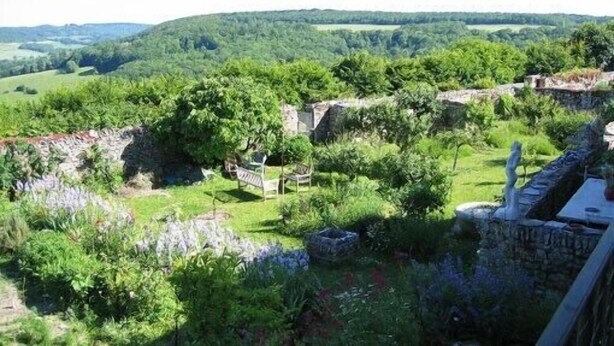 A garden with stone walls, a bench, and a statue. - A quiet and comfortable house in a burgundy's medieval village (Flavigny-Sur-Ozerain)