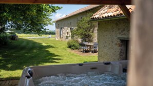 Een jacuzzi met een stenen gebouw op de achtergrond.