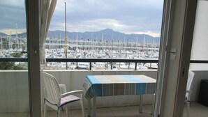 Un balcon donnant sur une marina, avec une table et une chaise.