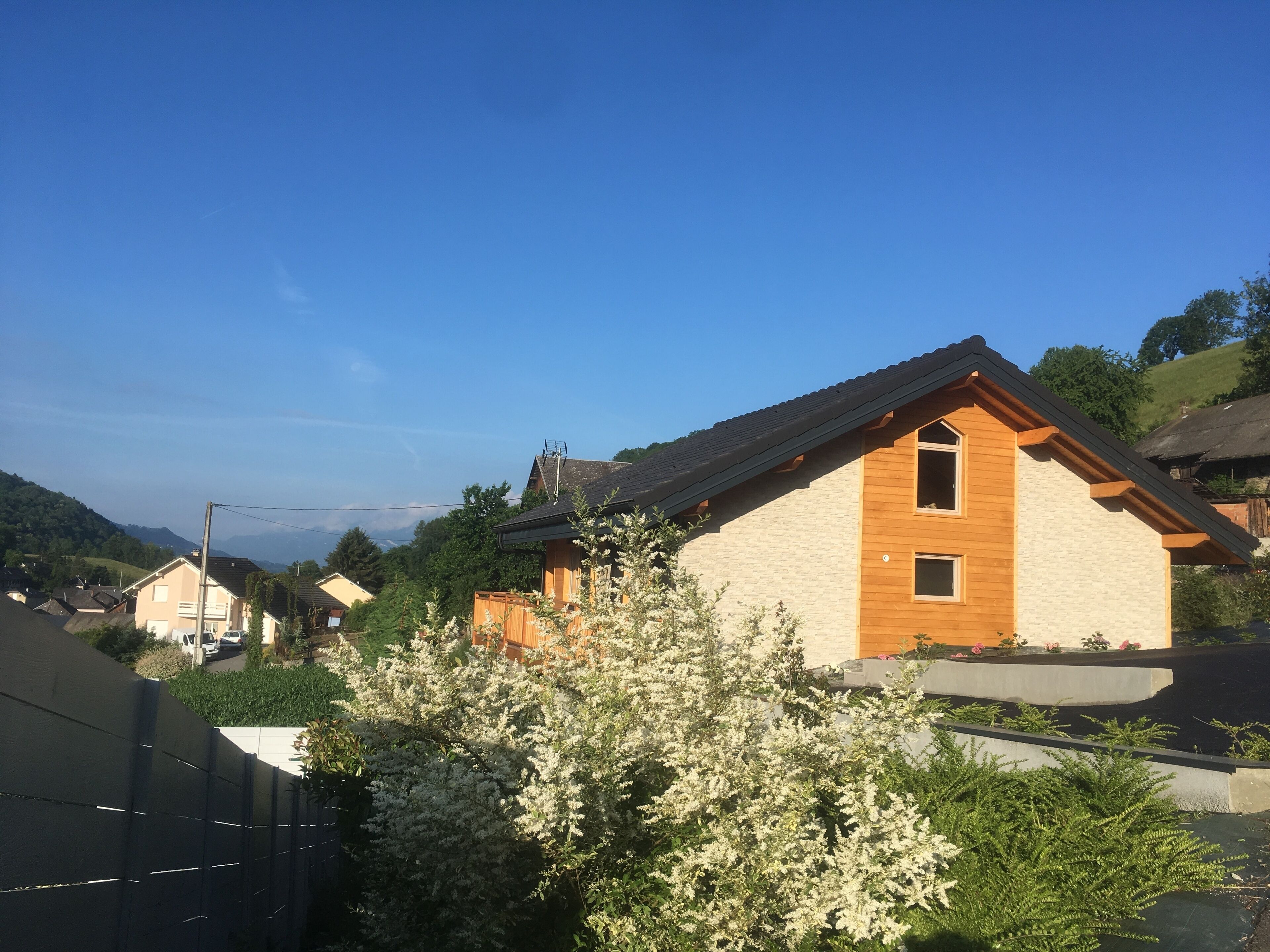 A house with a sloped roof, wooden exterior, and a small window.