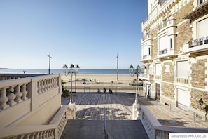 A coastal promenade with a view of the beach, a staircase leading to a building, and street lamps. - House with courtyard, 200 m from the Remblai and 3 minutes from Les Sables town center on foot! (Les Sables-D'olonne)