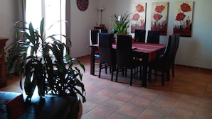 A dining area with a table and chairs, a clock on the wall, and a potted plant. - Beautiful Villa (Bastide) close to the sea and Pic Saint Loup (Sussargues)