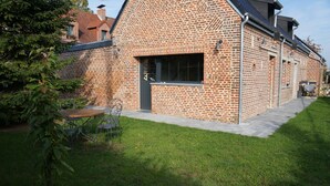 Ein Ziegelhaus mit großem Fenster und kleiner Terrasse.